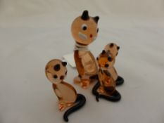Four miniature glass figures of a cat and her kittens.