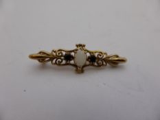 A 9ct hallmarked bar brooch set with an opal with two blue stones to each side, approx. 2.9 gms.