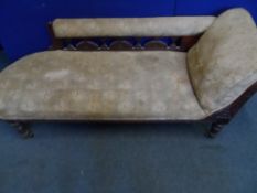 An Edwardian chaise longue, the mahogany frame having carved decoration, the back rest being on