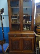 An Edwardian glazed front mahogany bookcase having two drawers with cupboards under to the base, the