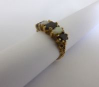 A lady`s 9 ct hallmarked gold garnet and opal gypsy ring, approx. 4 gms.