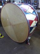 A large military style bass drum, painted in red, cream and blue with similar rope decoration,
