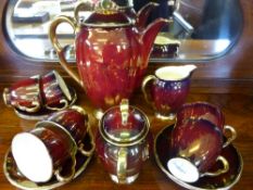 A Carlton Ware coffee set comprising six cups, six saucers, coffee pot, milk jug and sugar bowl, red