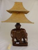 Indian Teak Carved Elephant converted to a lamp base with a pagoda shade of woven bamboo, signed