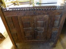 A large intricately carved Indian cupboard being hand painted with double doors
