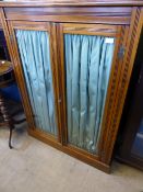 Edwardian mahogany glazed front bookcase having curtains to the interior with three shelves, the