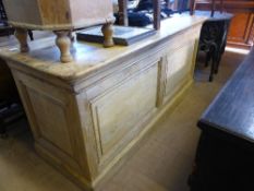 A French pine shop counter having panelled front, two drawers, a pull out slide and open shelf to