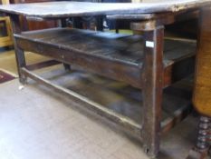 18th Century oak monk`s bench on square legs and stretchers and metal wheels, the seat being