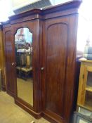 Large Victorian break front mahogany compactum having a mirrored centre door enclosing hanging space