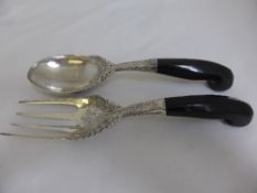 An antique hand made pair of Persian silver salad servers having ornate floral and laurel design
