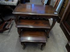 A nest of three mahogany tables having decorated frieze on cabriole legs with ball and plug feet.