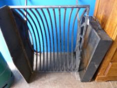 A large wrought iron fire basket on arched supports with a plain fire back approx. 82 x 60 x 52 cms.