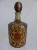 Antique Glass Decanter encased in a leather embossed cover with stopper, 29 cms h.