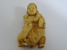 Japanese ivory netsuke in the form of an intricately carved gentleman and his dog, signed with two