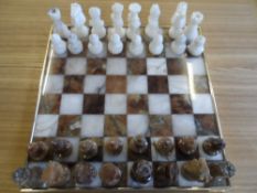Brass rimmed Marble Chess Board, with marble chess pieces 33 x 33 cms.