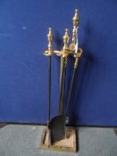 A part brass and cast iron companion set comprising tongs, shovel, poker and stand.