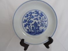 Chinese blue and white plate having central cartouche depicting Chinese vegetation, the exterior