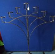 A vintage wrought iron candle stand having seven candle holders, approx. 143 cms. x 104 cms.