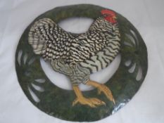 An enamel and tin decorative roundel depicting a rooster