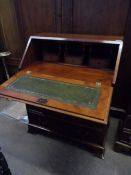 Yew wood bureau having a fitted interior with a green leather insert, four graduated drawers on