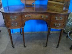 A Regency style lady`s dressing table being kidney shaped and of inlaid mahogany on tapered legs,