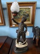 Continental Lamp depicting a Figure of a Boy holding aloft a flame, signed Fenning.