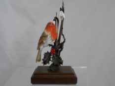 Porcelain model of a Robin, the figure on a metallic holly twig, with two snowdrops and metallic