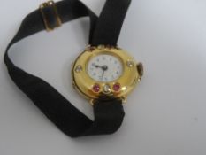 A vintage lady`s evening watch being 18 ct hallmarked gold, the watch set with rubies and diamonds