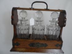 Oak and Brass Tantalus with three glass decanters.