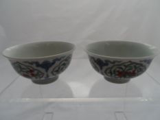 Pair of Chinese tea bowls, the tea bowls depicting seasonal fruit including pomegranate, peach,