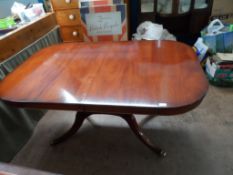 An Oval Mahogany Extending Dining Table; the table being on a central support comprising four turned