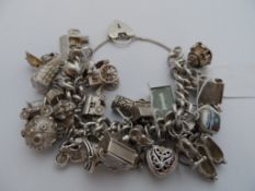 Solid Silver Charm Bracelet heart shaped clasp having 29 charms with safety chain. 160 grams.