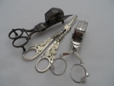 Antique Candle Snuffers, together with a pair of silver plated grape scissors.