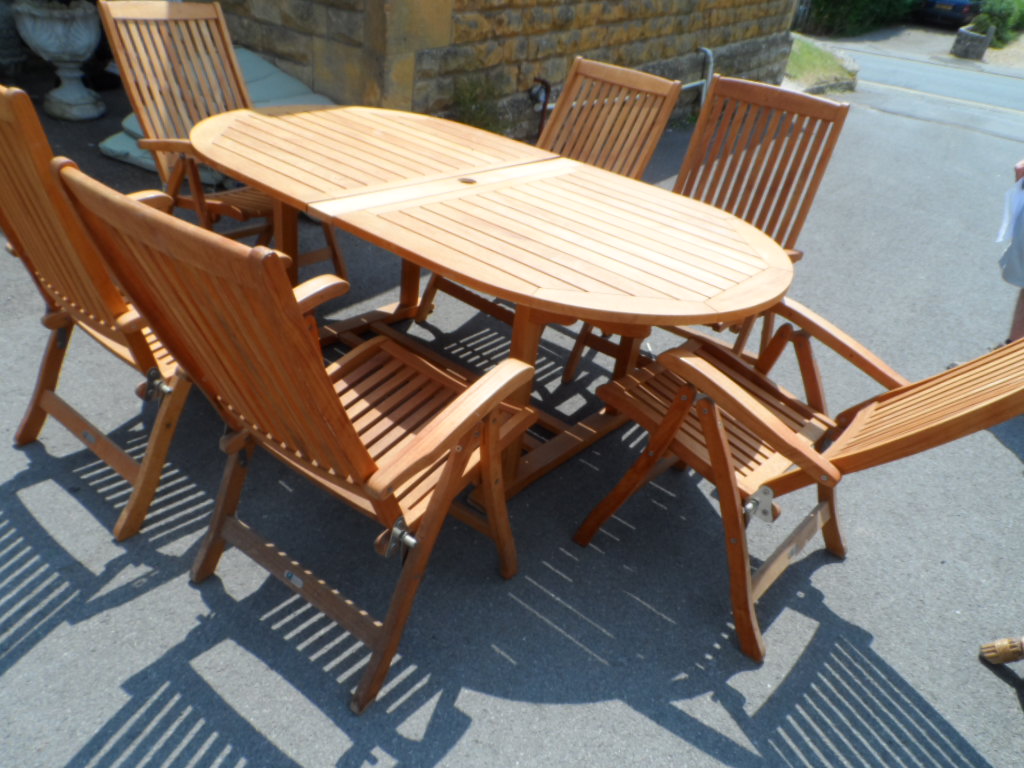A Teak Garden Table; the table being an extending eight seater together with a matching set of eight
