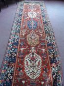 A Middle Eastern Hall Carpet; the woollen runner having a decorative border, approx. 420 x 129 cms.