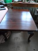 An Edwardian Mahogany Dining Table, the table being wind out with an extra leaf on cabriole legs and