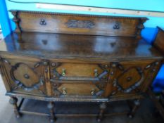 An Edwardian Oak Sideboard; the sideboard having carved decoration to the front and gallery with two