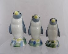 Three graduated Wade novelty spirit flasks, modelled as Penguins, decorated in subdued polychrome,