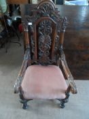 A Reproduction Elizabethan Style Oak Carver Chair, the chair having an X frame base with carved back