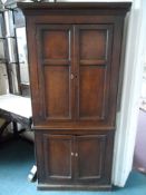 An antique oak farmhouse corner cupboard,, having panelled doors to top and bottom, approx. 90 x