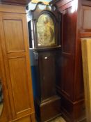 An oak cased antique grandfather clock, the clock being eight day and having a brass face, the