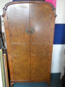 An Edwardian Gent`s wardrobe having drawers and a small mirrored cupboard to the right hand side and