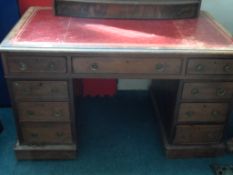 An Edwardian twin pedestal desk, the mahogany red leather topped desk having four drawers to each