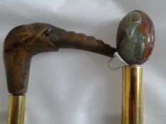 A Pair of Walking Sticks, one having a carved elephant head with glass eyes, the other depicting a