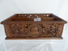 An intricately carved oak postal tray with the inscription "Loving all men - Fearing none" dated