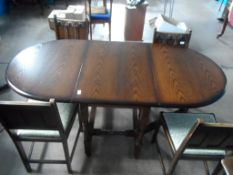 An oval oak drop leaf Dining Table on turned legs and stretchers together with a set of four