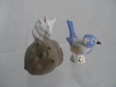 A Royal Copenhagen mouse sitting on a truffle together with a hand painted Russian bird.