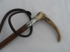 A Vintage leather riding whip, the leather horn handled whip having a silver collar inscribed “