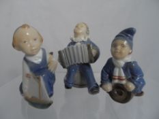 Royal Copenhagen porcelain figures including a boy playing accordion seated on a barrel nr 3667