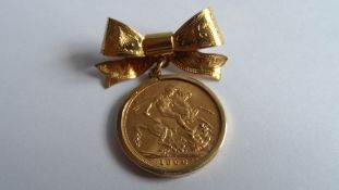 AN EDWARD VII 1906 FULL GOLD SOVEREIGN ON A 9ct GOLD HALLMARKED BOW BROOCH
